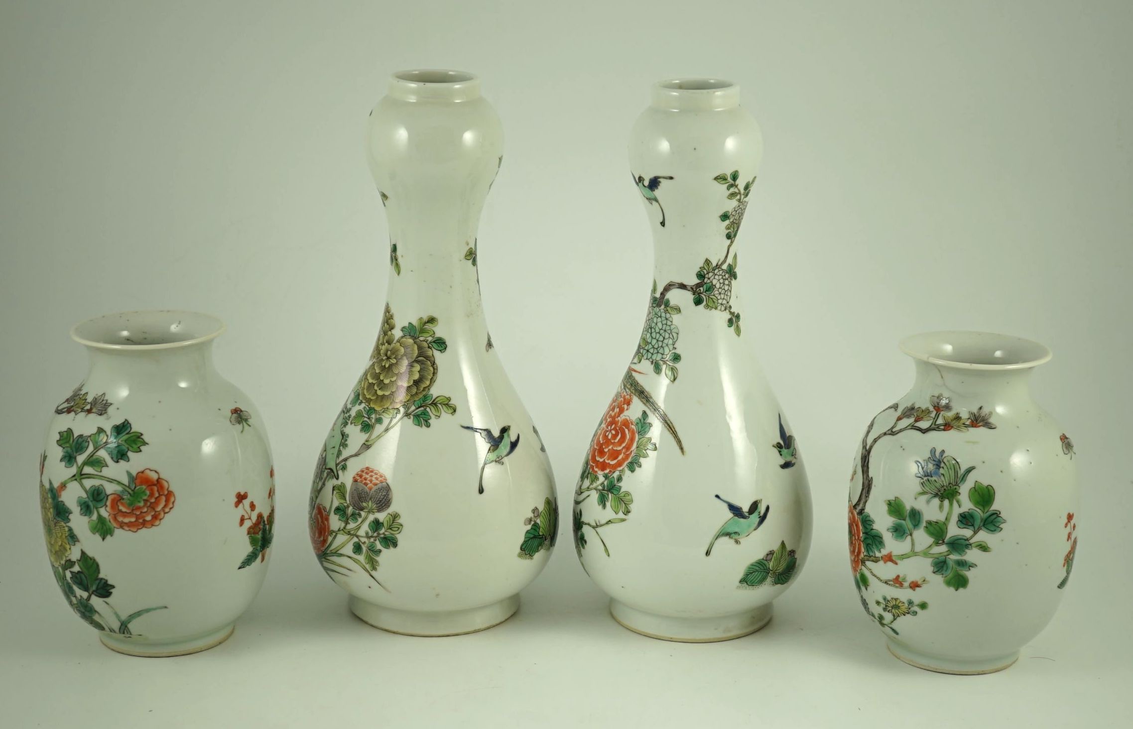 A garniture of four Chinese famille verte vases, 19th century, 31 cm and 17.5 cm high, one small vase cracked to neck